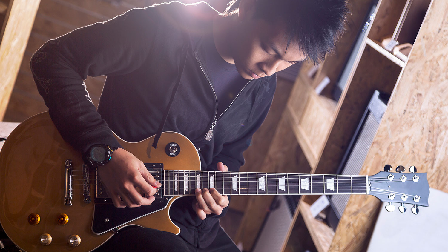 Um garoto jovem tocando uma guitarra Les Paulo