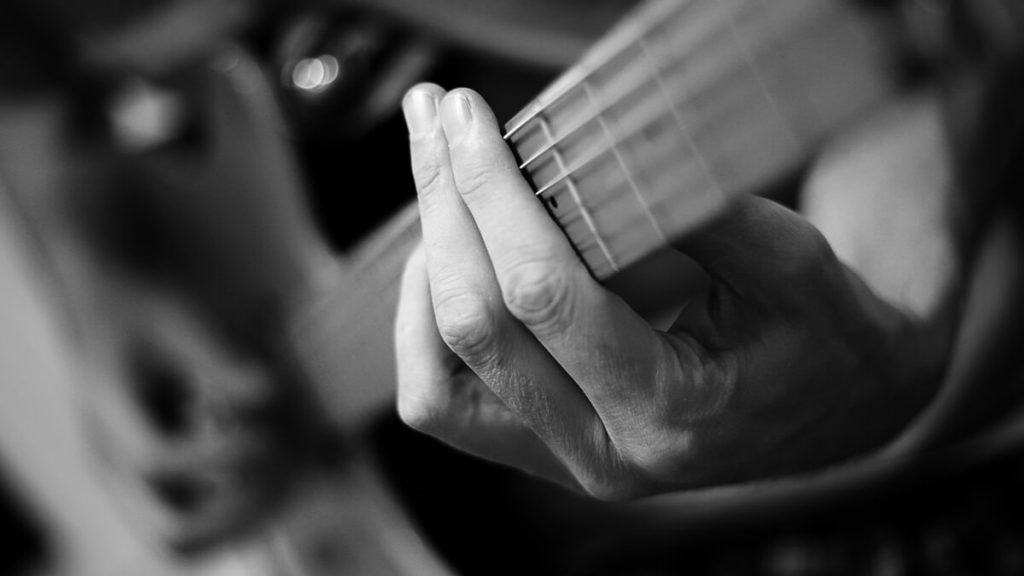Foto preto e branco com destaque em um Power Chord executado na guitarra